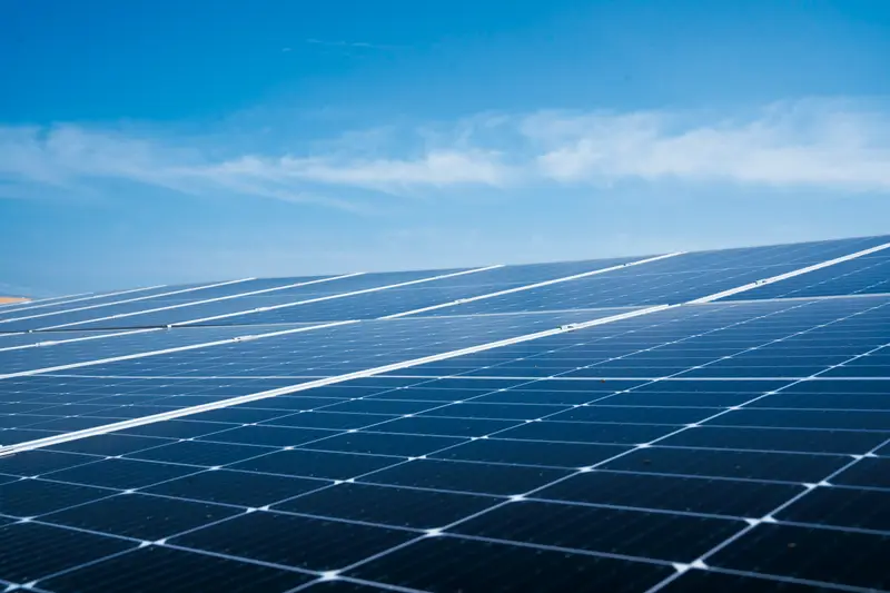Rangées de panneaux solaires bleus sous un grand ciel bleu ensoleillé